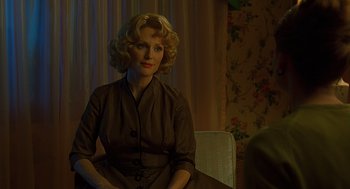 Movie still from “Far from Heaven” (2002), directed by Todd Haynes – A woman sitting on a chair in a room; Medium shot, Over the shoulder angle