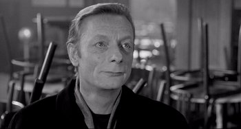 Movie still from “Faraway, So Close!” (1993), directed by Wim Wenders – Black and white photograph of a man in a restaurant; Close Up shot, Over the shoulder angle