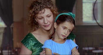 Movie still from “Faraway, So Close!” (1993), directed by Wim Wenders – A woman and a young girl posing for a picture; Close Up shot, Over the shoulder angle