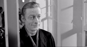 Movie still from “Faraway, So Close!” (1993), directed by Wim Wenders – An older man is smiling for the camera; Close Up shot, Over the shoulder angle