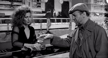 Movie still from “Faraway, So Close!” (1993), directed by Wim Wenders – A man and a woman in a black and white photo; Medium shot, Over the shoulder angle