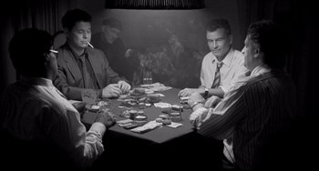 Movie still from “Faraway, So Close!” (1993), directed by Wim Wenders – A group of men sitting around a table playing cards; Medium shot, High angle
