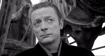 Movie still from “Faraway, So Close!” (1993), directed by Wim Wenders – Black and white photograph of a man looking into the distance; Close Up shot, Low angle