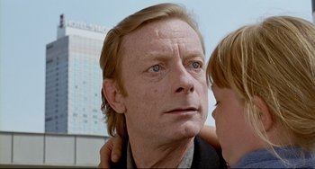 Movie still from “Faraway, So Close!” (1993), directed by Wim Wenders – A person with a child; Close Up shot, Over the shoulder angle