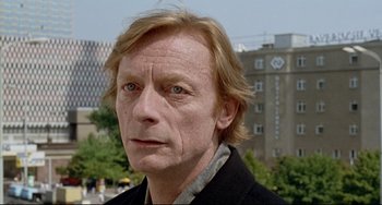 Movie still from “Faraway, So Close!” (1993), directed by Wim Wenders – A person wearing a black jacket; Close Up shot, Low angle