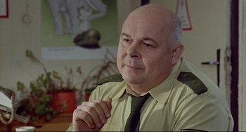 Movie still from “Faraway, So Close!” (1993), directed by Wim Wenders – An older man wearing a green neck tie; Close Up shot, Over the shoulder angle