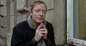 Movie still from “Faraway, So Close!” (1993), directed by Wim Wenders – A man in a black jacket and a scarf; Close Up shot, High angle