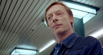 Movie still from “Faraway, So Close!” (1993), directed by Wim Wenders – A person wearing a blue shirt; Close Up shot, Low angle