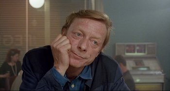 Movie still from “Faraway, So Close!” (1993), directed by Wim Wenders – A person with his hand under his chin; Close Up shot, High angle