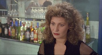 Movie still from “Faraway, So Close!” (1993), directed by Wim Wenders – A person with curly hair in a room; Close Up shot, Over the shoulder angle