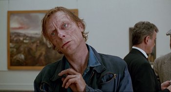 Movie still from “Faraway, So Close!” (1993), directed by Wim Wenders – A man with long blonde hair and a blue shirt; Close Up shot, Over the shoulder angle