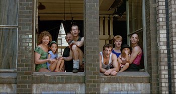 Movie still from “Faraway, So Close!” (1993), directed by Wim Wenders – A group of people sitting on top of a brick wall; Wide shot, High angle