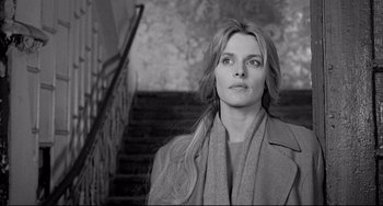 Movie still from “Faraway, So Close!” (1993), directed by Wim Wenders – Black and white photograph of a woman in front of a staircase; Close Up shot, Low angle
