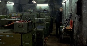 Movie still from “Faraway, So Close!” (1993), directed by Wim Wenders – A man standing in front of a room filled with boxes; Wide shot, High angle
