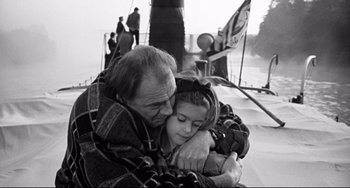 Movie still from “Faraway, So Close!” (1993), directed by Wim Wenders – An older man holding a young girl on a boat; Medium shot, High angle