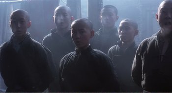 Movie still from “Farewell My Concubine” (1992), directed by Kaige Chen – A group of men standing next to each other in a dark room; Medium shot, Low angle