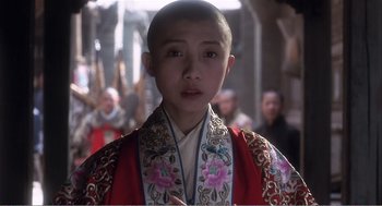Movie still from “Farewell My Concubine” (1992), directed by Kaige Chen – A young person wearing a red robe and a red and white robe; Close Up shot, Over the shoulder angle