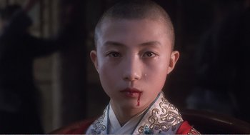 Movie still from “Farewell My Concubine” (1992), directed by Kaige Chen – A young boy with a blood stained shirt; Close Up shot, High angle