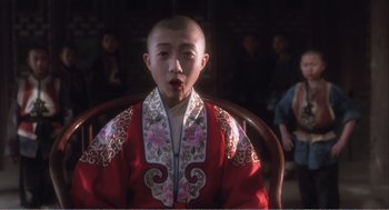 Movie still from “Farewell My Concubine” (1992), directed by Kaige Chen – A young man wearing a red robe with flowers on it; Medium shot, Low angle
