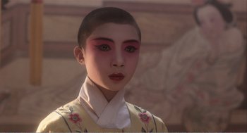 Movie still from “Farewell My Concubine” (1992), directed by Kaige Chen – A person with short black hair wearing a yellow and red outfit; Close Up shot, Low angle