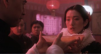 Movie still from “Farewell My Concubine” (1992), directed by Kaige Chen – A woman in a white dress is holding a plate; Close Up shot, Over the shoulder angle