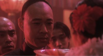 Movie still from “Farewell My Concubine” (1992), directed by Kaige Chen – A person sitting at a table; Close Up shot, Over the shoulder angle