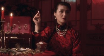 Movie still from “Farewell My Concubine” (1992), directed by Kaige Chen – A woman in a red dress is smoking a cigarette; Close Up shot, Low angle