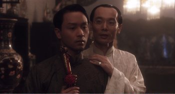 Movie still from “Farewell My Concubine” (1992), directed by Kaige Chen – A man and a man with a pipe in a room; Close Up shot, Over the shoulder angle