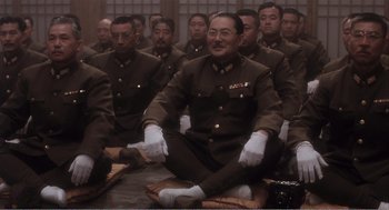 Movie still from “Farewell My Concubine” (1992), directed by Kaige Chen – A group of men in uniform sitting on the ground; Medium shot, High angle