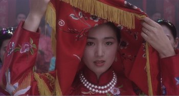 Movie still from “Farewell My Concubine” (1992), directed by Kaige Chen – A woman in a red dress with pearls around her neck; Close Up shot, Low angle