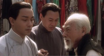 Movie still from “Farewell My Concubine” (1992), directed by Kaige Chen – A group of men standing next to each other in a room; Close Up shot, Over the shoulder angle