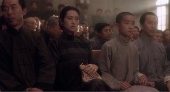 Movie still from “Farewell My Concubine” (1992), directed by Kaige Chen – A group of people sitting in a room; Medium shot, Low angle