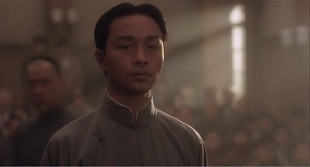 Movie still from “Farewell My Concubine” (1992), directed by Kaige Chen – A man in a gray shirt is looking at the camera; Close Up shot, Low angle