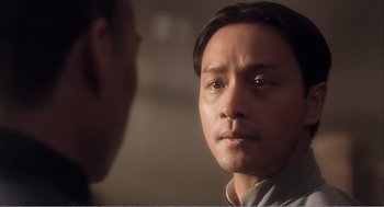 Movie still from “Farewell My Concubine” (1992), directed by Kaige Chen – A man stares at another man in a dimly - lit room; Close Up shot, Over the shoulder angle
