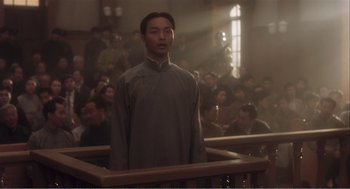 Movie still from “Farewell My Concubine” (1992), directed by Kaige Chen – A man standing in front of a group of people; Medium shot, Low angle