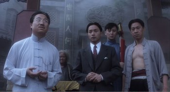 Movie still from “Farewell My Concubine” (1992), directed by Kaige Chen – A group of men standing in front of a painting; Medium shot, Low angle