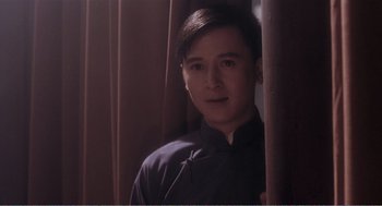 Movie still from “Farewell My Concubine” (1992), directed by Kaige Chen – A man in a black shirt is standing by a curtain; Close Up shot, Low angle
