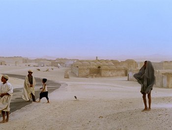 A group of people standing on top of a sandy beach