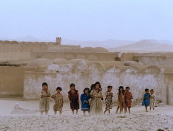 A group of children standing in the sand