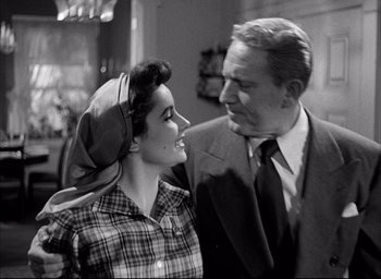 Movie still from “Father of the Bride” (1950), directed by Vincente Minnelli – An older man standing next to an older woman; Medium shot, Low angle