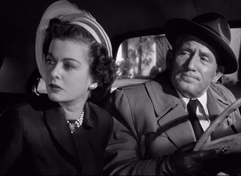 Movie still from “Father of the Bride” (1950), directed by Vincente Minnelli – An older man and a woman in a car with an open umbrella; Close Up shot, Low angle