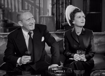 Movie still from “Father of the Bride” (1950), directed by Vincente Minnelli – An older man and woman sitting next to each other holding wine glasses; Medium shot, Low angle