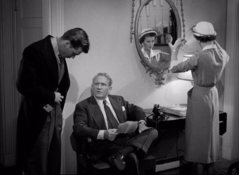 Movie still from “Father of the Bride” (1950), directed by Vincente Minnelli – A man sitting in front of a mirror in front of two other men; Medium shot, Over the shoulder angle
