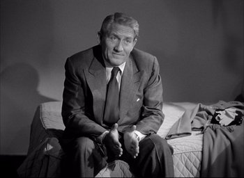 Movie still from “Father of the Bride” (1950), directed by Vincente Minnelli – An older man in a suit sitting on a couch; Medium shot, Low angle