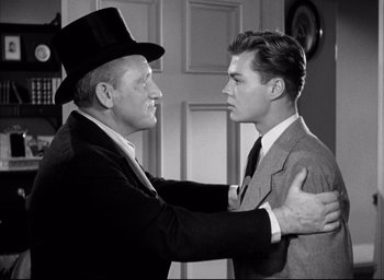Movie still from “Father of the Bride” (1950), directed by Vincente Minnelli – A man in a top hat and a man in a suit; Medium shot, Over the shoulder angle