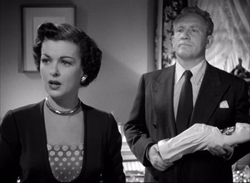 Movie still from “Father of the Bride” (1950), directed by Vincente Minnelli – An old photo of a man and a woman standing next to each other; Medium shot, Low angle