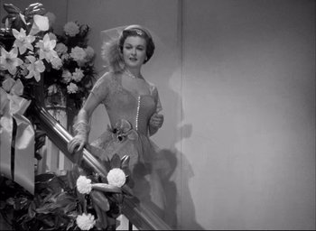 Movie still from “Father of the Bride” (1950), directed by Vincente Minnelli – A black and white photo of a woman walking down stairs; Medium shot, Low angle