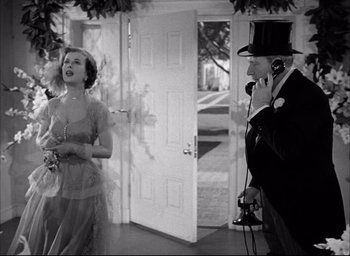 Movie still from “Father of the Bride” (1950), directed by Vincente Minnelli – A man and a woman are standing in front of a door; Medium shot, High angle