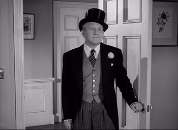 Movie still from “Father of the Bride” (1950), directed by Vincente Minnelli – A man wearing a top hat and a suit standing next to a door; Medium shot, Low angle