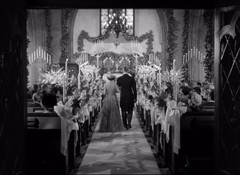 Movie still from “Father of the Bride” (1950), directed by Vincente Minnelli – A man and a woman walking down the aisle of a church; Wide shot, High angle